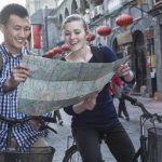 Young man and woman on bicycles, looking at map.