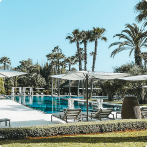 Luxury resort poolside in Morocco surrounded by palm trees and shaded sun loungers – a top pick for travel advisors and tour operators planning high-end wellness or leisure escapes