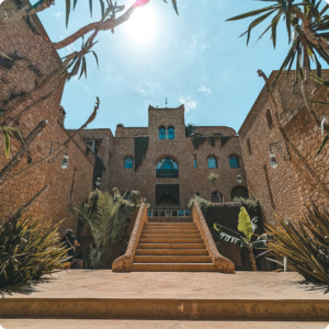 Majestic Moroccan kasbah-style hotel with grand stone staircase and traditional architecture – ideal for travel advisors and tour operators curating luxury cultural stays and heritage-inspired experiences in Morocco.